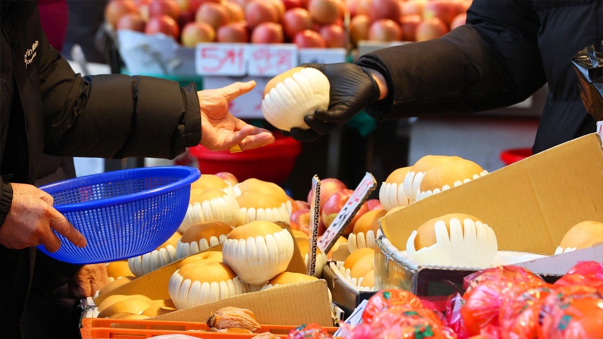 시장에서 과일을 구매 중인 시민 시장에서 과일을 구매 중인 시민